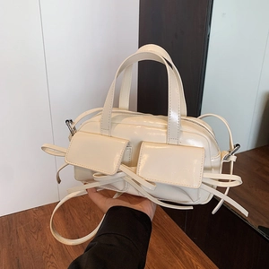 Creamy white patent leather handbag with bow decoration and double front pockets