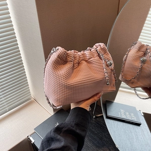 Pink waffle-textured cloud bag with silver chain strap shown in mirror reflection