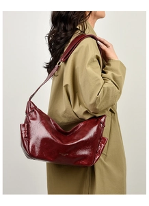 Detail view of glossy dark red leather tote bag showing side pocket and side profile
