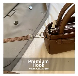 Macro view of high-quality silver hook and litchi texture on brown tote bag