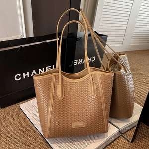 Detailed close-up of dark brown woven leather tote with intricate checkerboard texture