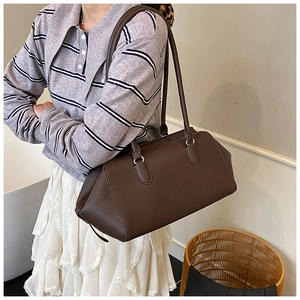Brown bowling shoulder bag with textured leather shown on model for daily casual wear