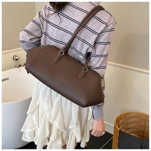 Detail of dark brown pebble leather shoulder bag showing texture and silver hardware