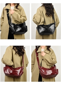 Detail of glossy wrinkled leather tote bags in black and burgundy with adjustable straps