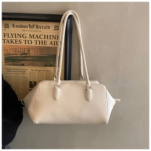 Close-up of cream bowling handbag in pebbled leather hanging on a retro wall