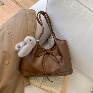 Minimalist large brown underarm tote bag with bow detail and plush rabbit charm
