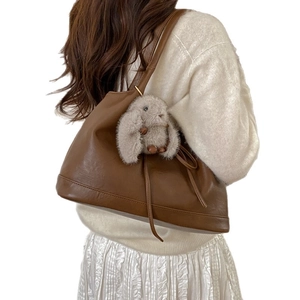 Brown leather shoulder bag for women with a cute grey plush bunny pendant charm
