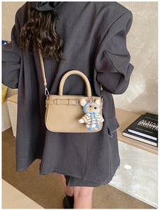 Detail of khaki tote bag with textured synthetic leather and cute bear charm accent