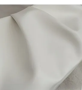 Close-up of soft pleated white PU leather fabric with fine texture and smooth finish