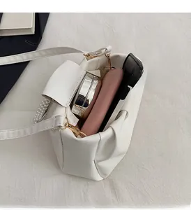 Spacious interior of white pleated crossbody bag showing phone, wallet, and makeup capacity