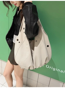 Détail du grand sac cabas blanc cassé avec œillets métalliques et design plissé chic