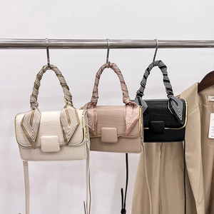 Détail de sacs à bandoulière en cuir avec rabats effet croco et poignées foulard