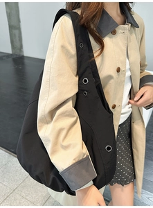Détail du grand sac à bandoulière noir avec œillets métalliques et texture plissée chic