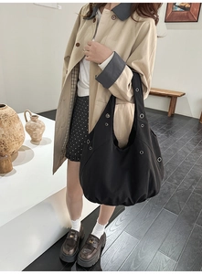 Détail d'un sac hobo en toile noire avec œillets montrant sa structure et sa texture