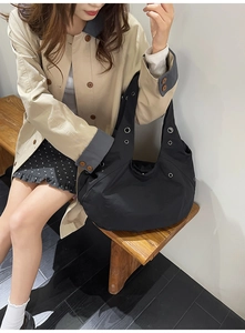 Vue latérale du grand sac hobo noir avec œillets argentés en toile de coton épais