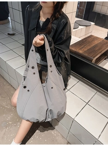 Détail du sac cabas gris avec oeillets métalliques et tissu texturé pour la mode