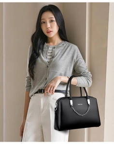 Détail du sac à main en cuir noir avec chaîne argentée et logo BALADO & BAG