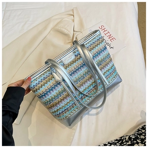Detail of multi-color woven tote bag with wavy patterns and silver metallic trim