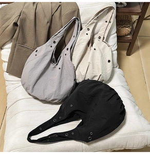 Détails de grands sacs cabas en toile gris, beige et noir avec des œillets métalliques