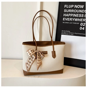 Detail of woven tote bag with brown leather trim and houndstooth silk scarf accent