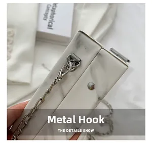 Detail of silver metal hook and marble texture resin bag with elegant chain strap