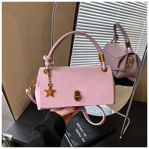 Detail of lavender litchi grain leather bag featuring star pendant and knot handle