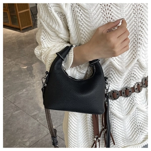 Close-up of black lychee grain texture and contrast white stitching on leather bag