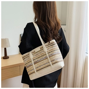 Fashionable striped woven tote bag with white leather handles shown on a shoulder