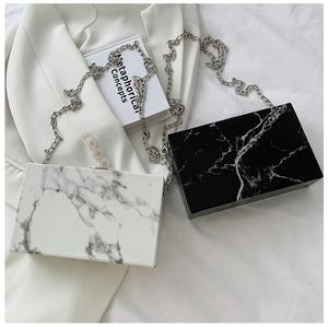 Detail of marble pattern acrylic box clutches with sleek silver metal chain straps
