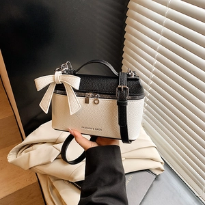 Urban chic black and white color-block handbag with bow detail and lychee texture