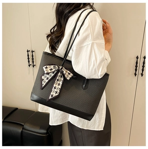 Detail of black woven tote bag with houndstooth silk scarf and elegant shoulder strap