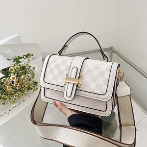 White checkered crossbody bag with wide woven strap and golden hardware accents