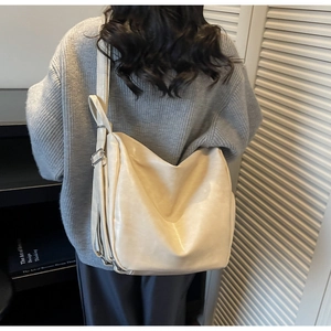 Close-up of cream PU leather tote bag with silver buckle and spacious interior design