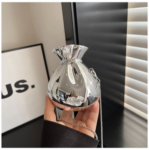 Detail of silver mirror finish chain bag with drawstring closure and metallic luster