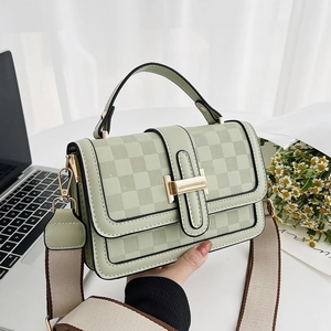 Light green textured shoulder bag with golden buckle and patterned fabric strap