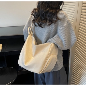 Detail showing creamy oversized hobo bag with smooth texture and side zipper pocket