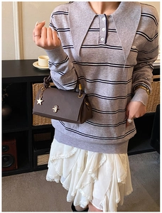 Detail of a brown leather square bag with star pendant and vintage twist lock