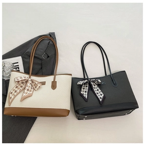 Detail of woven tote bags with leather trim and houndstooth silk scarf bows