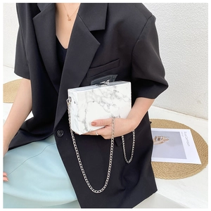 Fashionable marble pattern box clutch bag with silver chain strap worn by a model