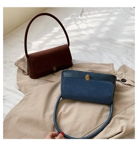 Detail of retro shoulder bags in brown and blue with suede texture and metal buckles