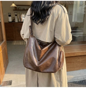 Detail of vintage brown hobo bag with side zipper pocket and soft faux leather texture
