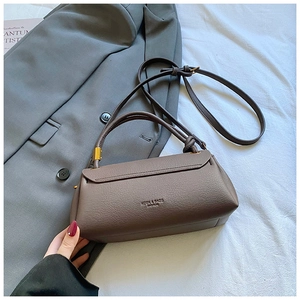 Detail shot of the dark khaki litchi texture leather bag with elegant metal hardware
