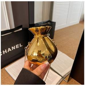 Macro detail of golden money bag shaped evening bag with metallic chain and pleated top