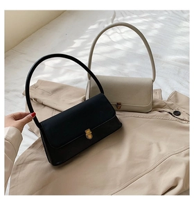 Detail view of vintage minimalist shoulder bags with metallic twist locks in black and cream