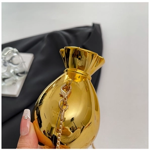 Detail of a gold fortune bag shaped evening clutch with a polished metallic mirror finish
