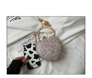 Macro detail of heart-shaped glitter evening bag with gold chain and handle
