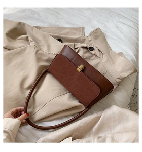 Detail of dark brown vintage handbag with suede flap, leather body, and gold twist lock