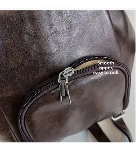 Detailed shot of a smooth silver zipper on a premium dark brown leather backpack