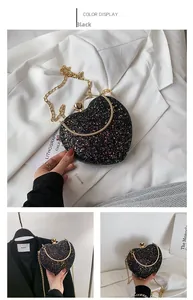 Detail of heart-shaped handbag with glitter sequins, gold chain, and gemstone clasp
