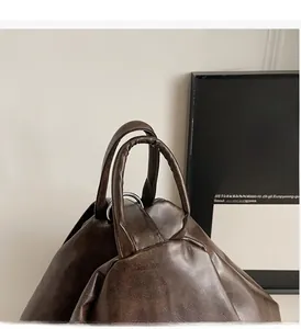 Detail of round reinforced double handles on dark brown leather backpack for women
